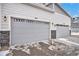 Two-car garage with gray doors and stone accents at 17217 E Exposition Dr, Aurora, CO 80017