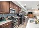 Modern kitchen with an island, stainless steel appliances, and tiled backsplash at 17217 E Exposition Dr, Aurora, CO 80017