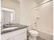 Bathroom with white vanity, dark countertop, and shower/tub combo at 5015 N Quemoy St, Aurora, CO 80019