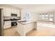 Modern kitchen with white cabinets, stainless steel appliances, and an island at 5015 N Quemoy St, Aurora, CO 80019