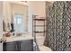 Bathroom featuring a sink, toilet, shower with a patterned curtain, and storage shelf at 5332 13Th St, Frederick, CO 80504