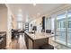 Open-concept kitchen with granite island, stainless appliances, and sliding glass doors to the patio at 5332 13Th St, Frederick, CO 80504