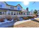 Tan two-story townhome with white trim, small fenced yard, and snow on ground at 1176 E 130Th Ave # C, Thornton, CO 80241