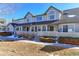 Tan two-story townhome with white trim, small fenced yard, and snow on ground at 1176 E 130Th Ave # C, Thornton, CO 80241