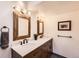 Double vanity bathroom with wood framed mirrors, updated fixtures, and gray flooring at 3026 W Prentice Ave # G, Littleton, CO 80123