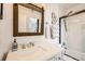 Updated bathroom featuring glass shower, white vanity, and rustic mirror at 3026 W Prentice Ave # G, Littleton, CO 80123