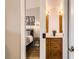 View from bedroom into bathroom with wooden vanity and mirrors at 3026 W Prentice Ave # G, Littleton, CO 80123