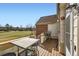 Outdoor deck overlooking a grassy field with furniture, a white door and brick building in background at 3026 W Prentice Ave # G, Littleton, CO 80123