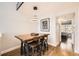 Dining area with a rustic wooden table and hardwood flooring, illuminated by a modern light fixture at 3026 W Prentice Ave # G, Littleton, CO 80123