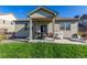 Cozy covered back patio features a dining set and grill for outdoor enjoyment and relaxation at 697 Gamble Oak St, Brighton, CO 80601