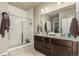 Bathroom showcasing a double sink vanity, glass-enclosed shower, and neutral finishes, perfect for a modern lifestyle at 697 Gamble Oak St, Brighton, CO 80601