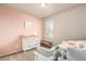 Comfortable bedroom with a pink accent wall, plush carpet and white wooden furniture at 697 Gamble Oak St, Brighton, CO 80601