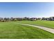 Beautiful community park featuring a large grassy field, walking path, and covered picnic area, surrounded by well-maintained homes at 697 Gamble Oak St, Brighton, CO 80601