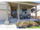 Inviting front porch with comfortable seating and colorful hanging flower baskets at 697 Gamble Oak St, Brighton, CO 80601