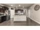 Spacious kitchen with stainless steel appliances, dark wood cabinets, and a large center island, offering ample storage and prep space at 697 Gamble Oak St, Brighton, CO 80601
