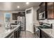 Modern kitchen with stainless steel appliances, granite countertops, and dark wood cabinets at 697 Gamble Oak St, Brighton, CO 80601