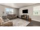Spacious living room with hardwood floors, neutral paint, and modern entertainment center at 697 Gamble Oak St, Brighton, CO 80601