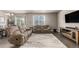 Comfortable living room featuring plush reclining sofas, a large window, and hardwood floors at 697 Gamble Oak St, Brighton, CO 80601
