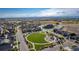 Aerial image of a neighborhood featuring a central park with walking paths, play area and a vibrant community atmosphere at 697 Gamble Oak St, Brighton, CO 80601