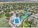 Beautiful aerial view of community pool, tennis courts, volleyball court, lake, and surrounding mature trees at 982 E 130Th Cir, Thornton, CO 80241