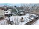 Aerial view of a home with a fenced backyard and covered patio area, all covered in snow at 982 E 130Th Cir, Thornton, CO 80241