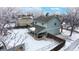 Aerial view of snow covered home with covered back patio and playset at 982 E 130Th Cir, Thornton, CO 80241