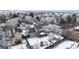 Aerial view of a snow-covered house with a fenced backyard and covered patio at 982 E 130Th Cir, Thornton, CO 80241