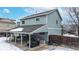 A snow-covered backyard with a covered patio and outdoor seating at 982 E 130Th Cir, Thornton, CO 80241