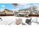 View of backyard with covered patio, grill, outdoor seating, and snow covered ground at 982 E 130Th Cir, Thornton, CO 80241