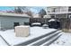 A snow-covered backyard patio features modern outdoor furniture and a grill, perfect for entertaining in any season at 982 E 130Th Cir, Thornton, CO 80241