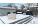 Snowy backyard featuring a patio with a table, chairs, grill, and a storage shed at 982 E 130Th Cir, Thornton, CO 80241
