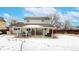 View of the backyard with patio and snow covered ground of this two story home at 982 E 130Th Cir, Thornton, CO 80241