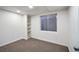 Cozy basement bedroom with neutral carpet, white walls, a window, and built-in shelves at 5960 S Jellison St # B, Littleton, CO 80123