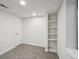 Basement bedroom featuring neutral carpet, white walls, a closet, and built-in shelves at 5960 S Jellison St # B, Littleton, CO 80123