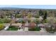 A wide aerial view of the neighborhood showcasing lush trees and homes with well-kept lawns under a blue sky at 1359 S Brentwood Way, Lakewood, CO 80232