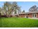 Expansive backyard featuring lush green lawn and mature trees, perfect for outdoor activities and relaxation at 1359 S Brentwood Way, Lakewood, CO 80232