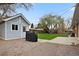 Landscaped backyard with blue shed, a covered grill, green grass, and a concrete patio area at 1359 S Brentwood Way, Lakewood, CO 80232