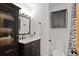 Bathroom featuring dark cabinets, a marble countertop, and elegant decorative wallpaper at 1359 S Brentwood Way, Lakewood, CO 80232