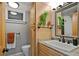 Stylish half-bath featuring wood grain cabinets, granite counters, modern fixtures and a decorative mirror at 1359 S Brentwood Way, Lakewood, CO 80232