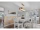 An airy dining area with a wooden chandelier, a large white table with chairs, and hardwood floors at 1359 S Brentwood Way, Lakewood, CO 80232