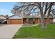 Well-kept single-level house with a brick front, neat landscaping, and a wide driveway leading to the garage at 1359 S Brentwood Way, Lakewood, CO 80232