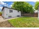 Backyard with white brick house and a lawn area, enclosed by a wooden fence at 1845 W 39Th Ave, Denver, CO 80211