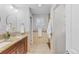 Bathroom featuring double sinks with granite countertops and a walk-in shower at 1845 W 39Th Ave, Denver, CO 80211