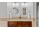 Dual sink bathroom with a granite countertop, updated fixtures, and decorative mirrors at 1845 W 39Th Ave, Denver, CO 80211