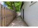 The side yard features a narrow walkway, wooden fence, and white brick exterior at 1845 W 39Th Ave, Denver, CO 80211