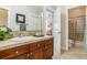 Bright bathroom with a wooden vanity, a tile backsplash, and a shower with a glass door at 25015 E Park Crescent Dr, Aurora, CO 80016