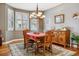 Elegant dining room with a bay window, chandelier, and traditional furnishings on a decorative rug at 25015 E Park Crescent Dr, Aurora, CO 80016