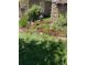 Landscaping featuring green grass, mulch, flowers and a nearby stone column at 25015 E Park Crescent Dr, Aurora, CO 80016