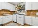 Well-lit laundry room featuring a washer, dryer, cabinetry, and stylish decor at 25015 E Park Crescent Dr, Aurora, CO 80016