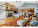 Open-concept living room with a stone fireplace, hardwood floors, and seamless transition to the kitchen at 25015 E Park Crescent Dr, Aurora, CO 80016